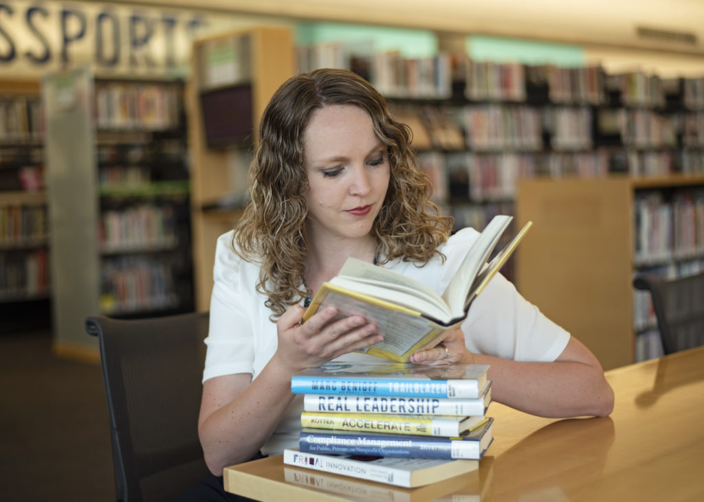 Ashley de Tello reading a book in a library